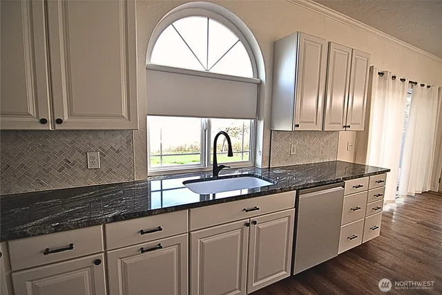 a kitchen with stainless steel appliances granite countertop a sink a stove and cabinets