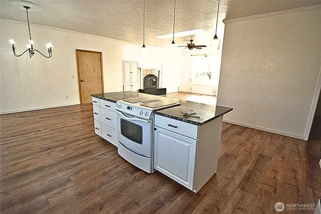 a kitchen with a stove and wooden floor