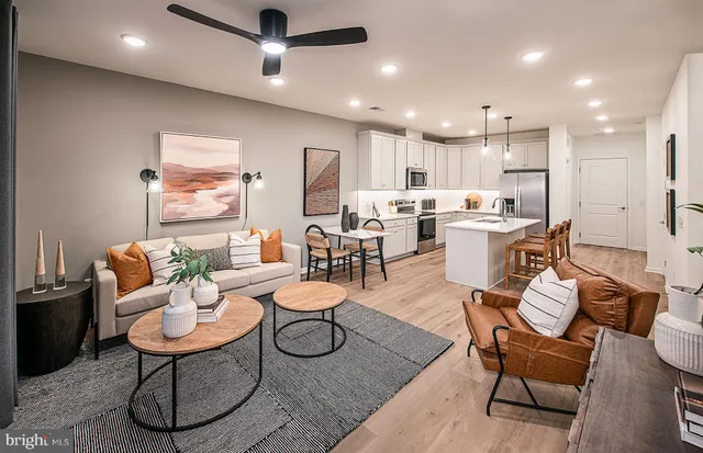 a living room with furniture a rug and kitchen view