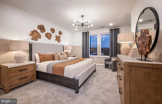 a spacious bedroom with a bed and a chandelier