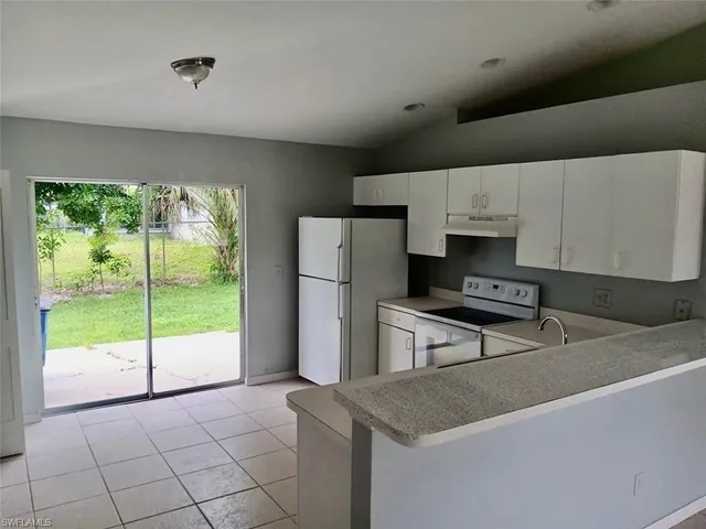 a kitchen with kitchen island a stove a refrigerator and a sink with wooden cabinets