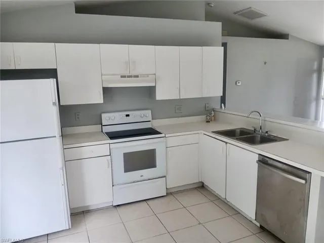 a kitchen with white cabinets and white appliances