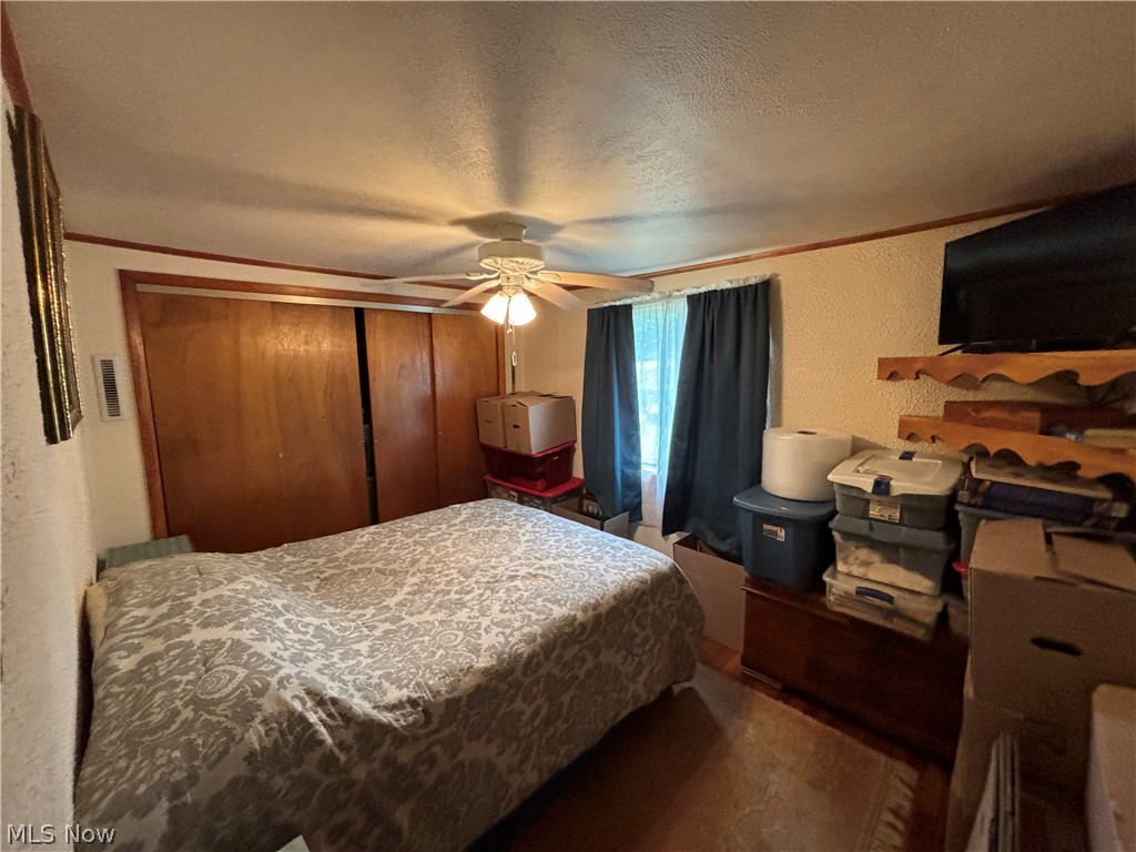 2417 Mc Adoo Ridge Road Wellsburg, WV 26070 - Photo 12 of 33 Bedroom featuring a closet, ceiling fan, and a textured ceiling