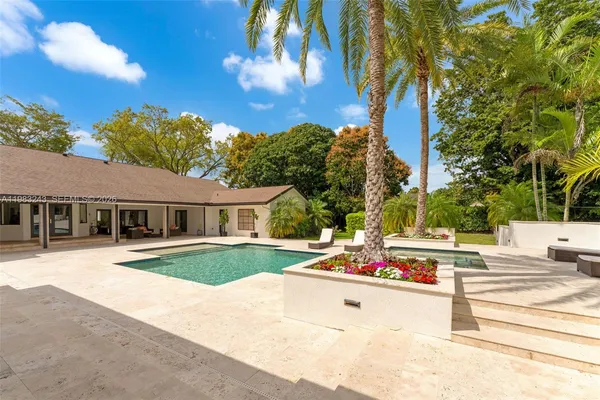 a view of swimming pool with a table and chairs under an umbrella