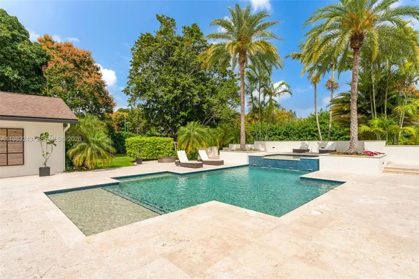 a view of a house with backyard water fountain and sitting area