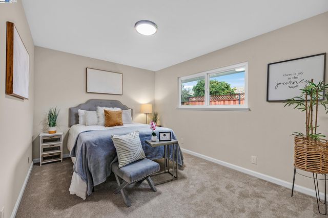 a bedroom with a bed and a painting on the wall