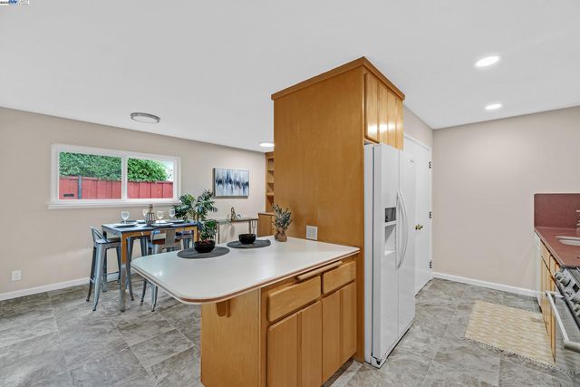a view of a kitchen area with furniture and refrigerator