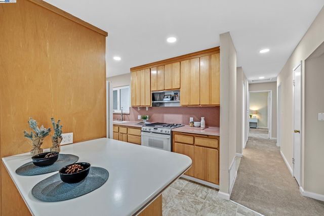 a kitchen with stainless steel appliances granite countertop a sink dishwasher stove and refrigerator with wooden floor