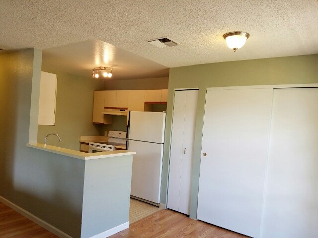 140 Uwapo Road, Unit 22204 Kihei, HI 96753 - Photo 7 of 19 a room with refrigerator and wooden floor