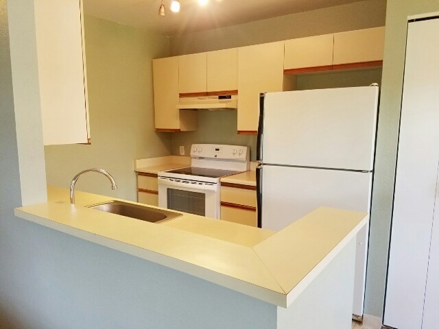 140 Uwapo Road, Unit 22204 Kihei, HI 96753 - Photo 8 of 19 a kitchen with a sink a stove and a refrigerator