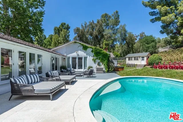 a living room with fireplace furniture and a large window