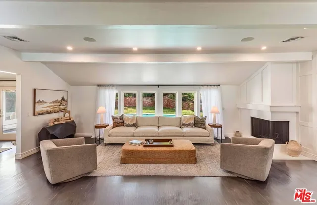 a living room with furniture fireplace and a large window