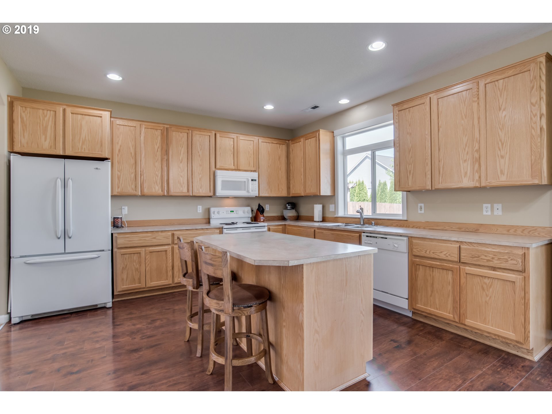 2014 North Falcon Drive Ridgefield, WA 98642 - Photo 8 of 32 a kitchen with a table chairs refrigerator and cabinets