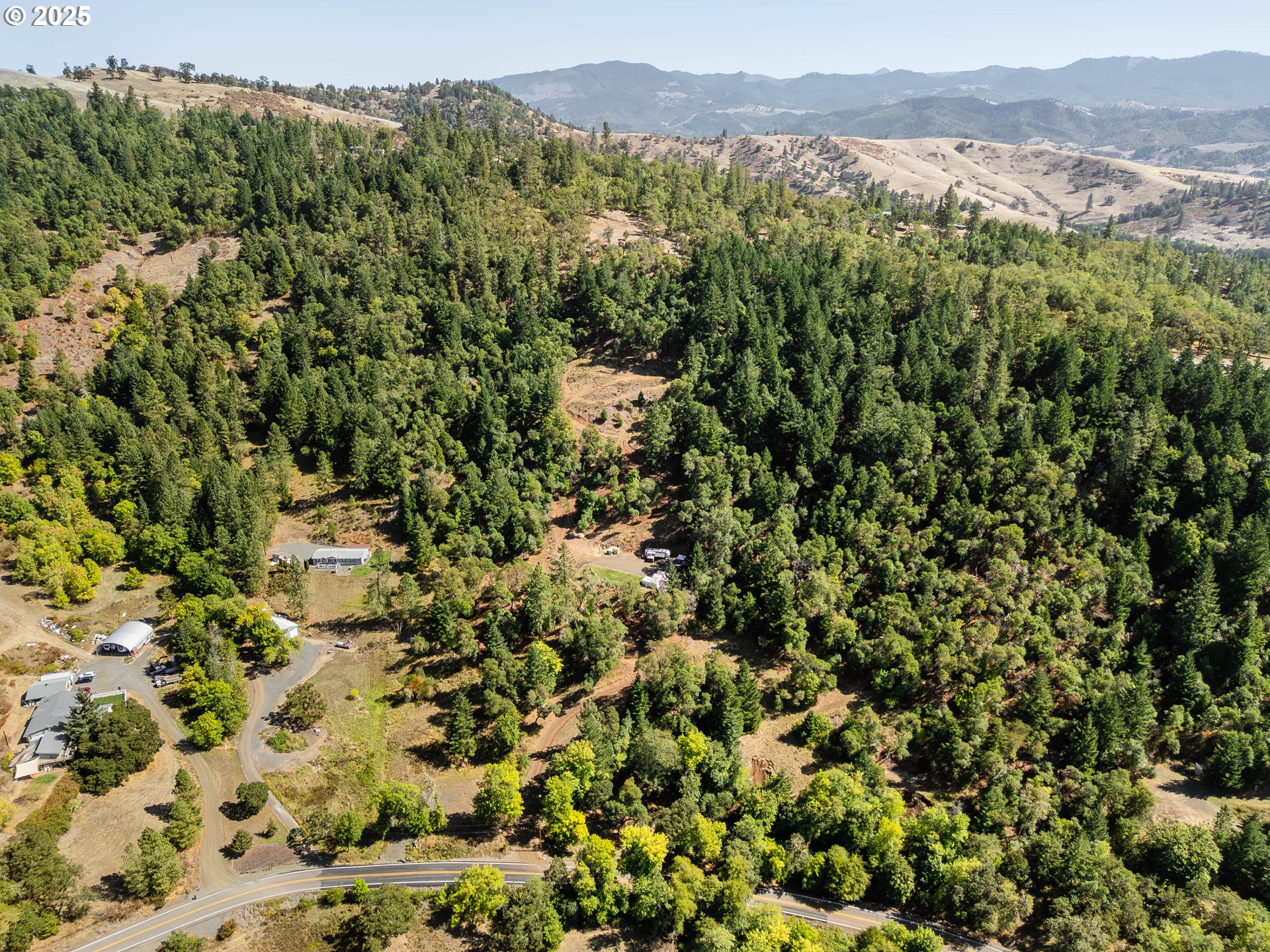 an aerial view of a houses with a lush green hillside