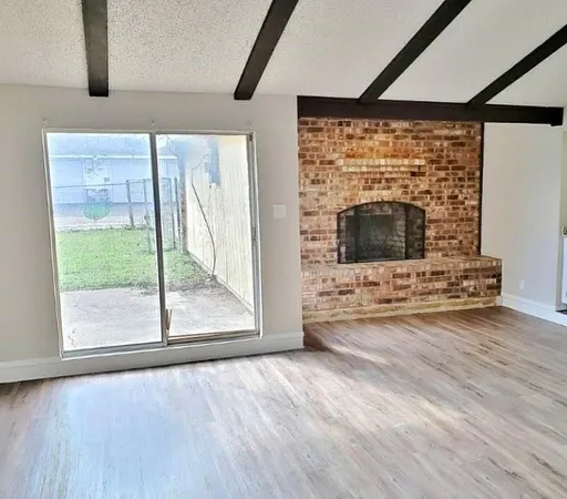 a view of a livingroom with wooden floor and a fireplace