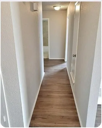 a view of a hallway with wooden floor