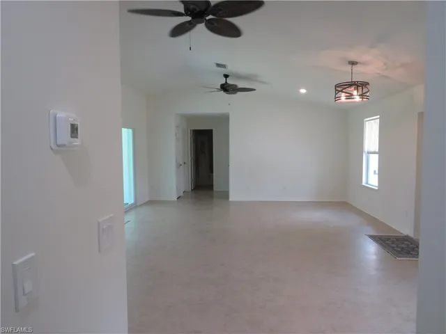 a view of a big room with windows and chandelier fan