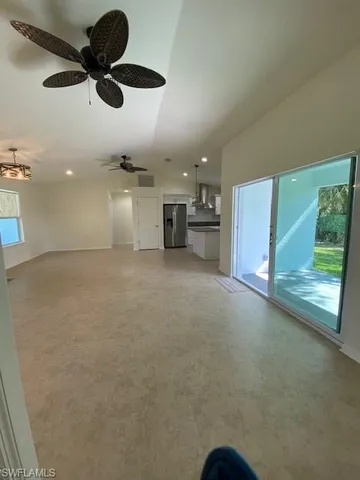 a view of a livingroom with a ceiling fan a kitchen space a sink a ceiling fan and kitchen view