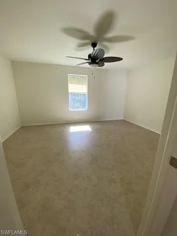 an empty room with wooden floor cabinet and windows