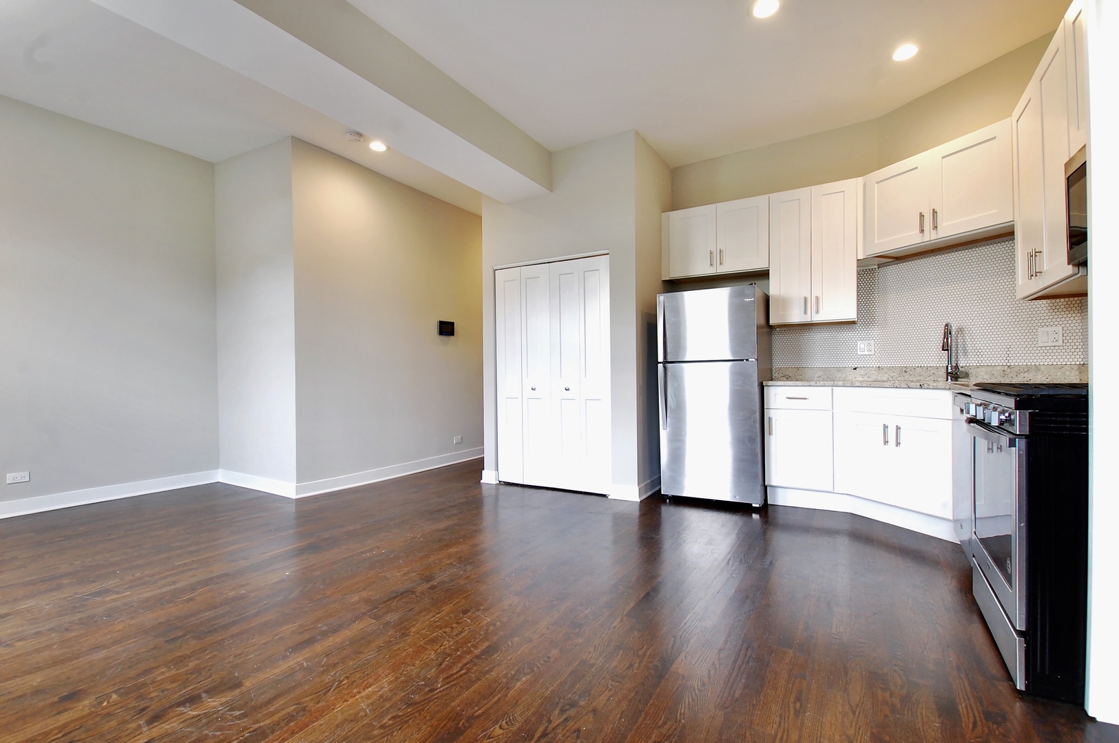 1854 West 18th Street, Unit 2F Chicago, IL 60608 - Photo 4 of 5 a kitchen with stainless steel appliances a refrigerator and wooden floor