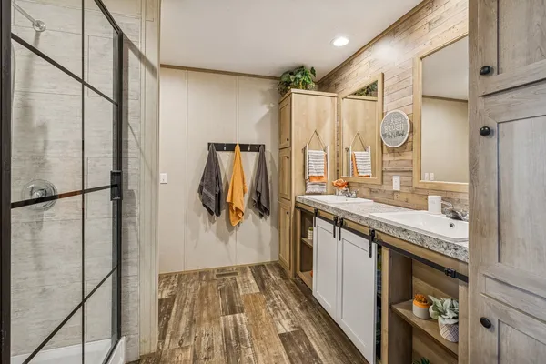 a bathroom with a granite countertop shower a sink and a mirror
