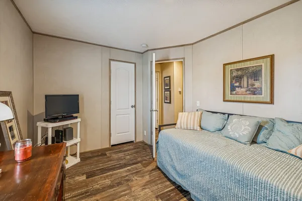 a spacious bedroom with a bed and flat screen tv