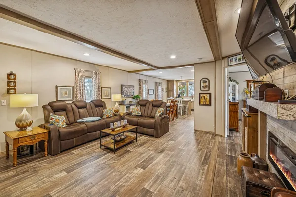 a living room with furniture a flat screen tv and a wooden floor