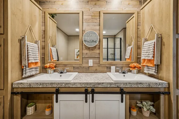 a bathroom with a granite countertop double vanity and a sink