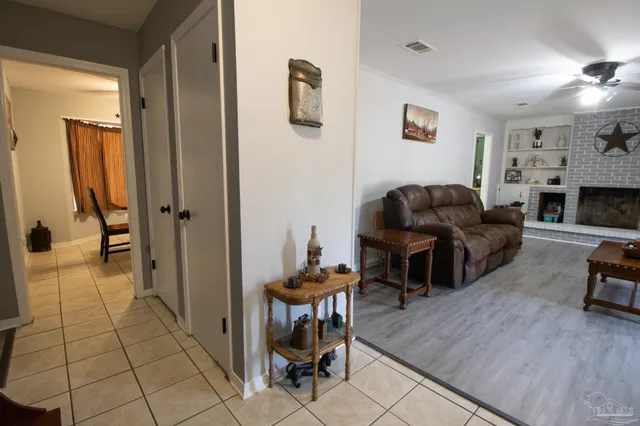 a living room with furniture a flat screen tv and a chandelier