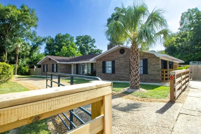 front view of house with a yard and potted plants
