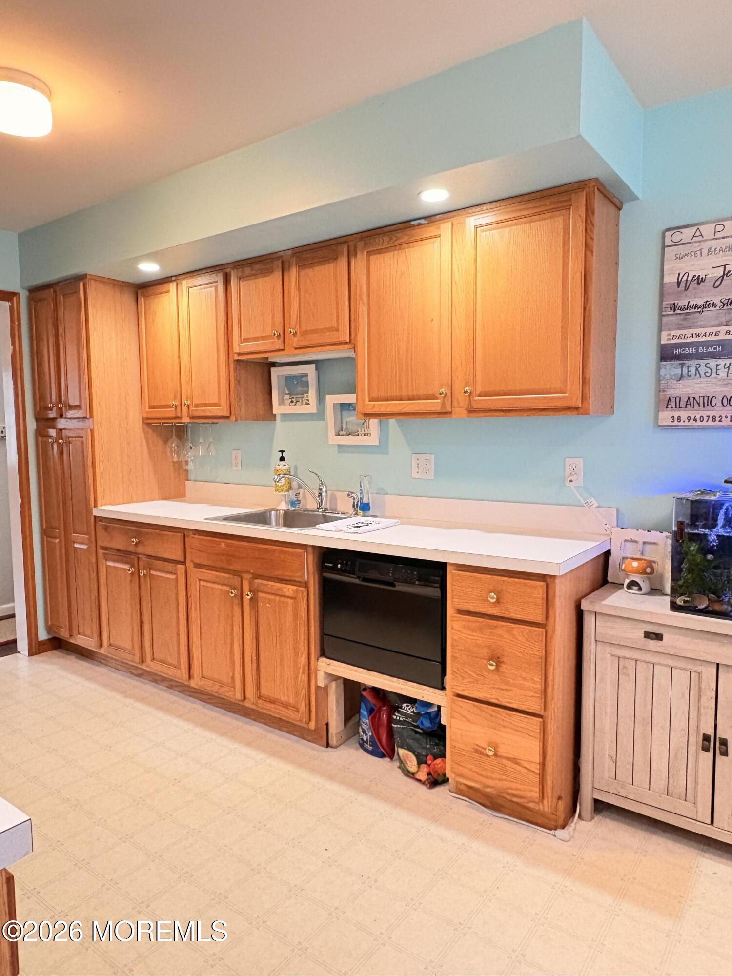 456 Dock Road Forked River, NJ 08731 - Photo 8 of 14 a kitchen with stainless steel appliances kitchen island wooden cabinets a sink and a large window
