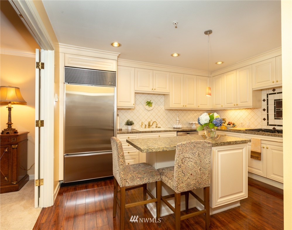 1331 Harbor Avenue Southwest, Unit 103 Seattle, WA 98116 - Photo 12 of 32 a kitchen with a refrigerator a sink and cabinets