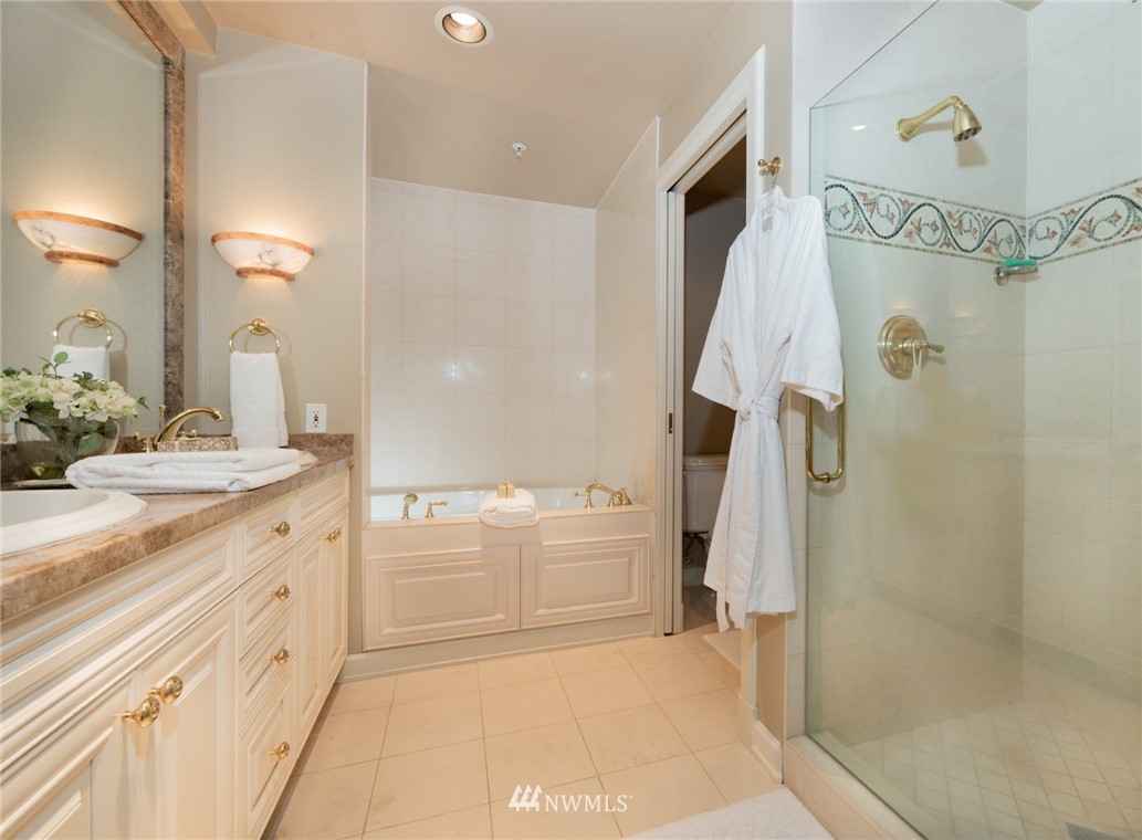 1331 Harbor Avenue Southwest, Unit 103 Seattle, WA 98116 - Photo 24 of 32 a bathroom with a granite countertop sink a mirror and a shower