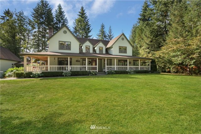 a front view of a house with a yard and trees
