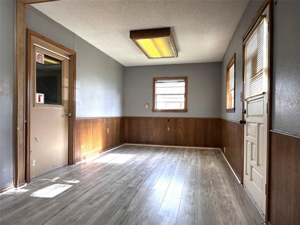 205 First Street Bangs, TX 76823 - Photo 3 of 16 an empty room with wooden floor and windows