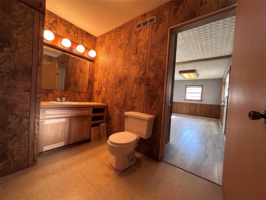 205 First Street Bangs, TX 76823 - Photo 6 of 16 a bathroom with a toilet sink and mirror