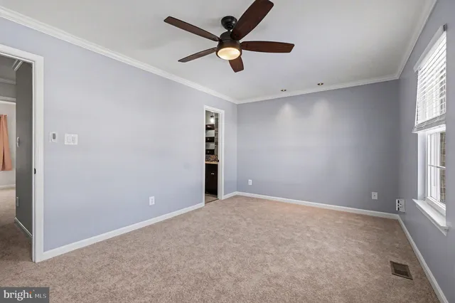 an empty room with closet and windows