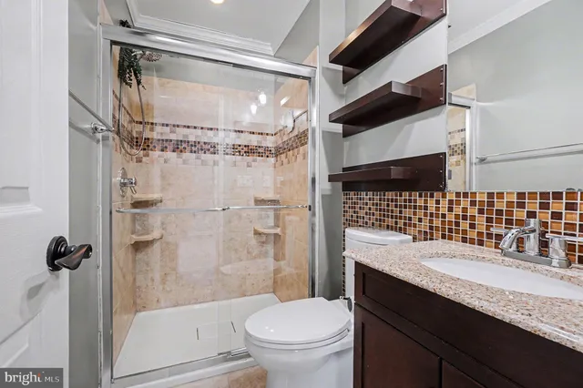 a bathroom with a granite countertop sink toilet and shower