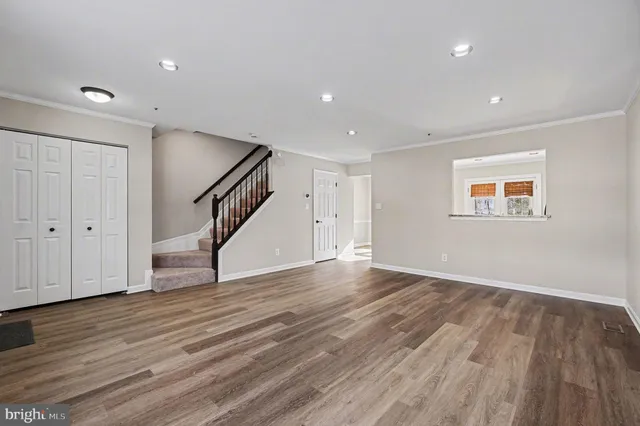 a view of empty room with wooden floor and stairs