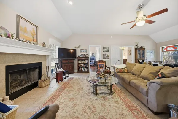 a living room with furniture a fireplace and a flat screen tv
