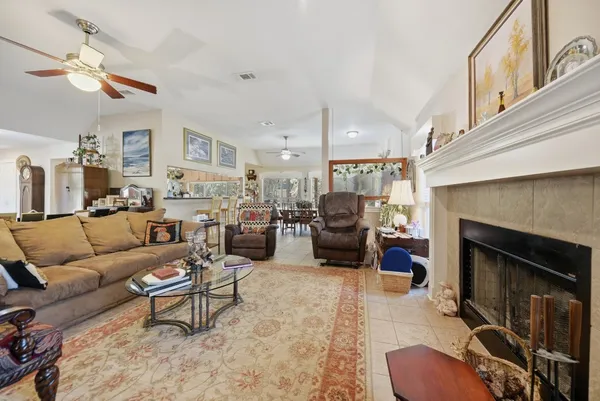 a living room with furniture kitchen view and a fireplace