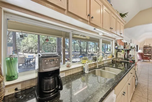 a kitchen with stainless steel appliances granite countertop a sink a stove and a wooden cabinets