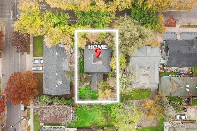 front view of house with a yard and large trees