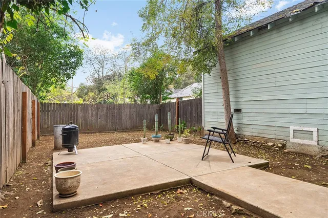 a backyard with a table and chairs and a barbeque
