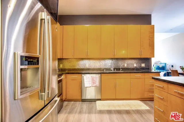 a kitchen with stainless steel appliances granite countertop a refrigerator and a sink