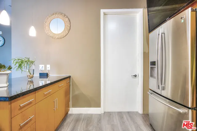 a kitchen with stainless steel appliances granite countertop a refrigerator a sink a stove and wooden floors