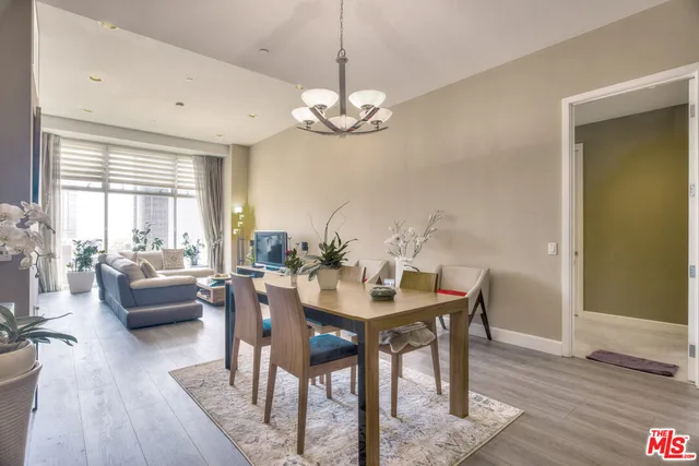 a view of a dining room with furniture a chandelier and wooden floor