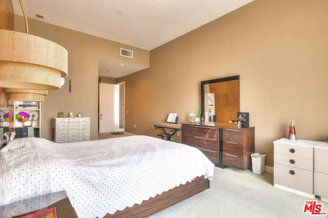 a bedroom with a bed and a large mirror on dresser