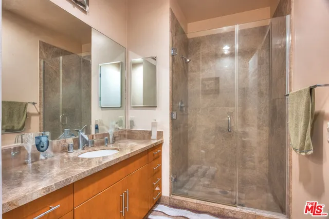 a bathroom with a granite countertop sink mirror and shower