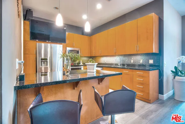 a kitchen with stainless steel appliances wooden cabinets a stove a sink and a microwave